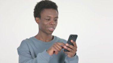Casual African Man Browsing Smartphone on White Background