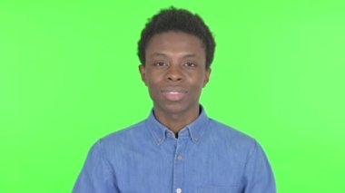 Casual African Man Waving Hand to Say Hello on Green Background