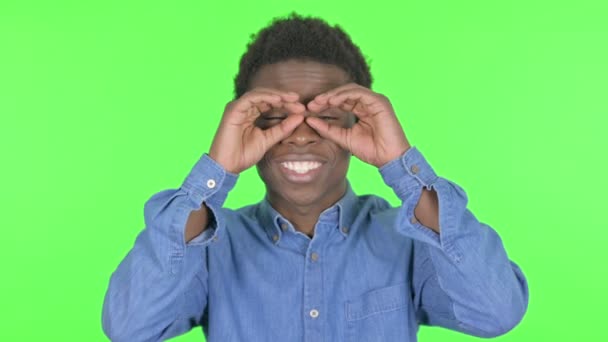 Casual African Man Looking Handmade Binocular Green Background — Stock video