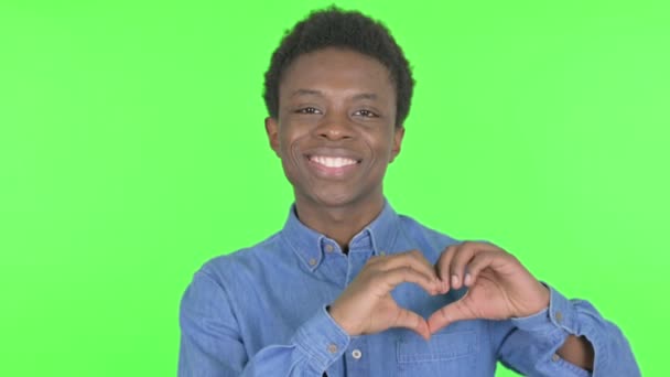 緑の背景に愛の心を示すカジュアルアフリカ人男性 — ストック動画