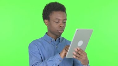 Casual African Man Celebrating Success on Tablet on Green Background