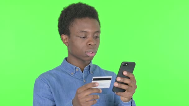 緑の背景にオンライン決済の問題を抱えているカジュアルアフリカ人男性 — ストック動画