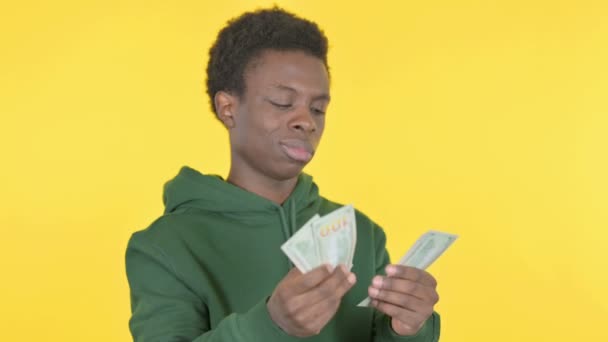 Случайный Африканский Человек Считает Доллары Жёлтом Фоне — стоковое видео