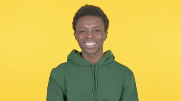 黄色の背景で頭を振るカジュアルアフリカ人男性による承認 — ストック動画