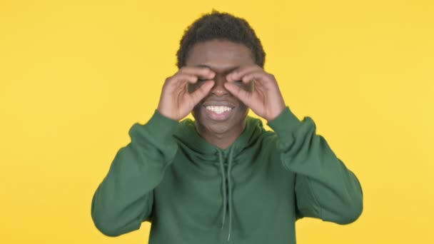 Casual African Man Searching Handmade Binocular Yellow Background — Vídeos de Stock
