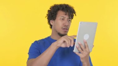 Casual African Man Reacting to Loss on Tablet on Yellow Background