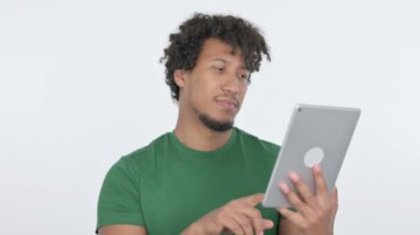 Casual African Man Celebrating Success on Tablet on White Background