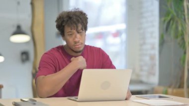 Pensive Young African Man Working on Laptop