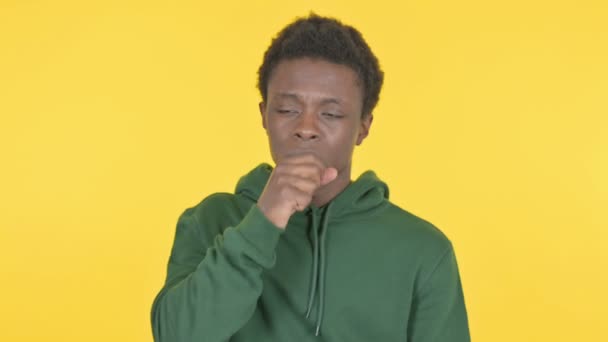 黄色の背景で咳をする病気のカジュアルアフリカ人男性 — ストック動画