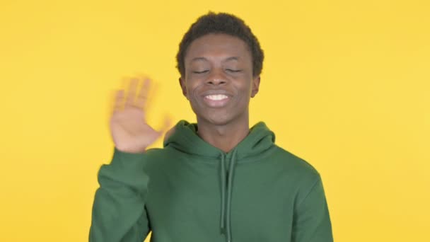 黄色の背景にオンラインビデオ通話で話すカジュアルアフリカ人男性 — ストック動画