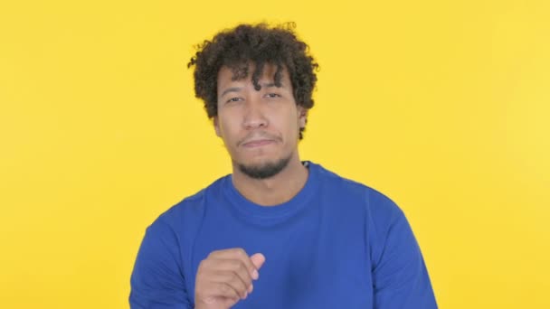 黄色の背景にカメラを向けるカジュアルアフリカ人男性 — ストック動画