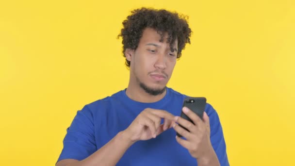Casual African Man Loss Smartphone Yellow Background — Stockvideo