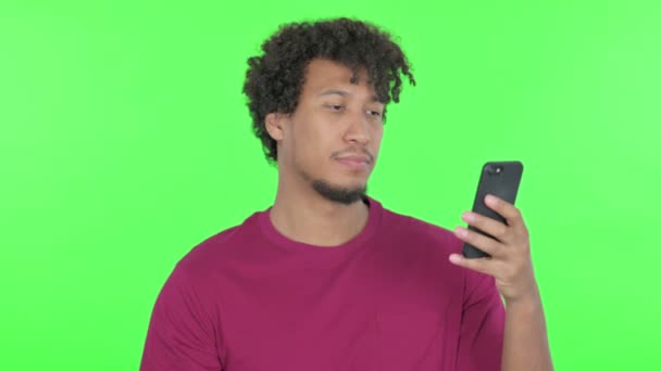 Casual African Man Loss Smartphone Green Background — Vídeo de Stock