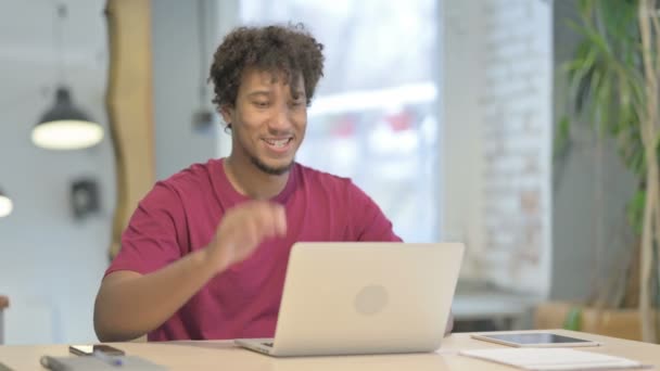 若いアフリカ人男性がオフィスでオンラインビデオチャットを行う — ストック動画