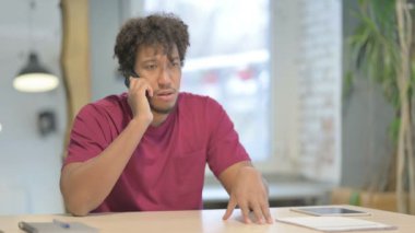 Upset Young African Man Talking Angrily on Smartphone