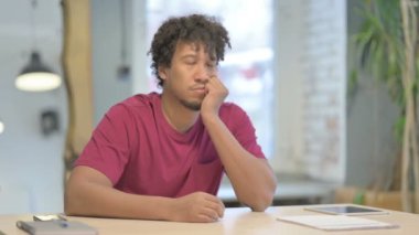 Tired Young African Man Sleeping while at Work