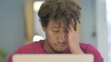 Close Up of Young African Man having Headache while Working on Laptop