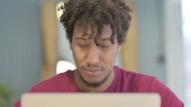 Close Up of Thumbs Up by Young African Man Working on Laptop