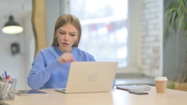 Young Woman Coughing while Working on Laptop