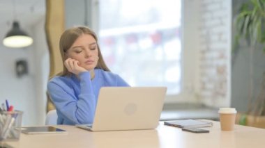 Young Woman Sleeping while Working on Laptop