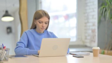 Dizüstü bilgisayar kullanırken Kameraya Bakan Genç Kadın