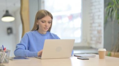 Başparmak yukarıya üstünde Laptop çalışan genç kadın tarafından