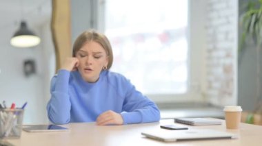 Embarrassed Young Woman Sitting in Depression and Anxiety at Work