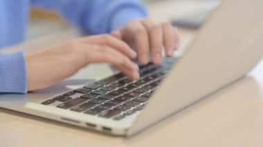 Genç kadının dizüstü bilgisayarda yazarak yakın çekim