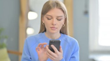 Young Woman using Smartphone for Browsing Internet
