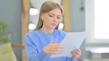 Young Woman Reading Documents in Office, Doing Paperwork