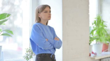 Serious Young Woman Looking at Camera while Standing Near Window