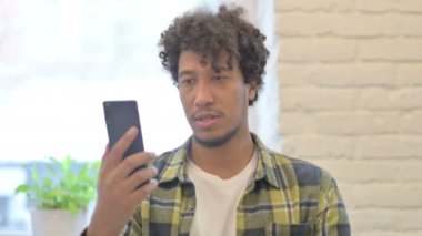 Excited Young African Man Celebrating Win on Smartphone
