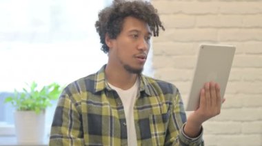 Young African Man Cheering Success on Digital Tablet