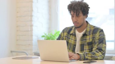 Busy Young African Man Typing on Laptop in Office