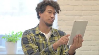 Young African Man Browsing Internet on Digital Tablet