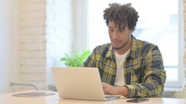 Thumbs Down by Young African Man Working on Laptop