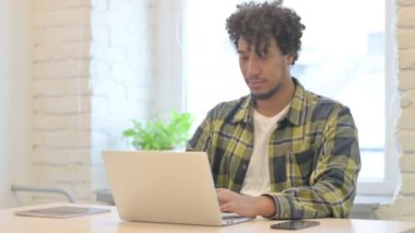 Young African Man Leaving Office after Closing Laptop
