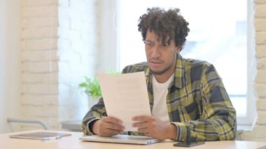 Tense Young African Man Feeling Upset after Reading Documents