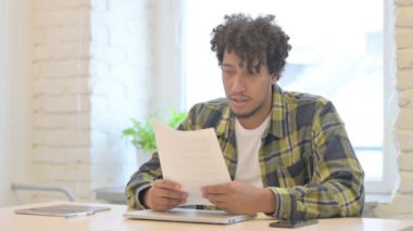 Young African Man Feeling Excited after Reading Documents