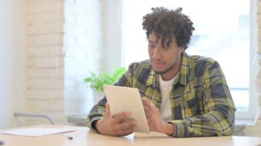 Young African Man Cheering Win on Digital Tablet