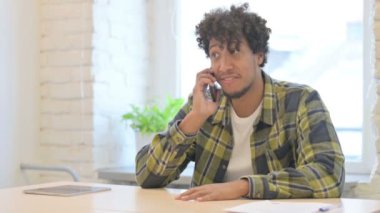 Displeased Young African Man Talking in Anger on Phone