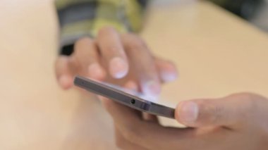 Close up of Young African Man Browsing Internet on Smartphone