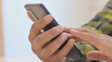 Close up of Young African Man Using Smartphone for Browsing Internet