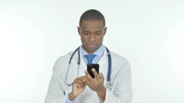 Young African Doctor Browsing Smartphone on White Background