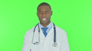 Thumbs Up by Young African Doctor on Green Background