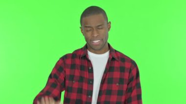 Young African Man Waving Hand to Say Hello on Green Background