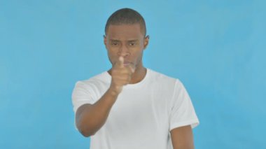 Young African Man Pointing at the Camera on Blue Background