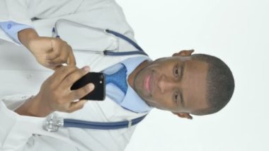 Vertical Video of Young African Doctor Browsing Smartphone on White Background