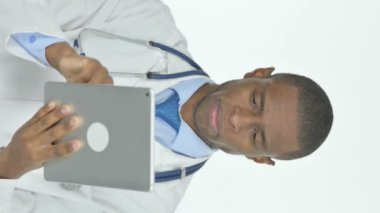 Vertical Video of Young African Doctor Using Digital Tablet on White Background