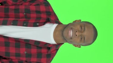 Vertical Video of Smiling Young African Man on Green Background